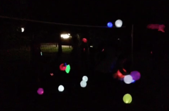 farbig leuchtende Luftballons vor dunklem Hintergrund