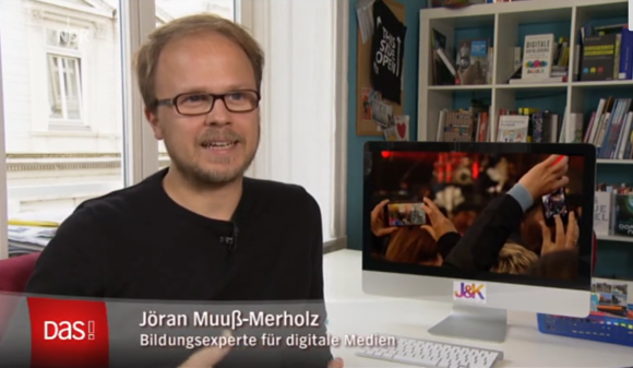Jöran Muuß-Merholz sitzt an einem Schreibtisch und gibt ein Interview.